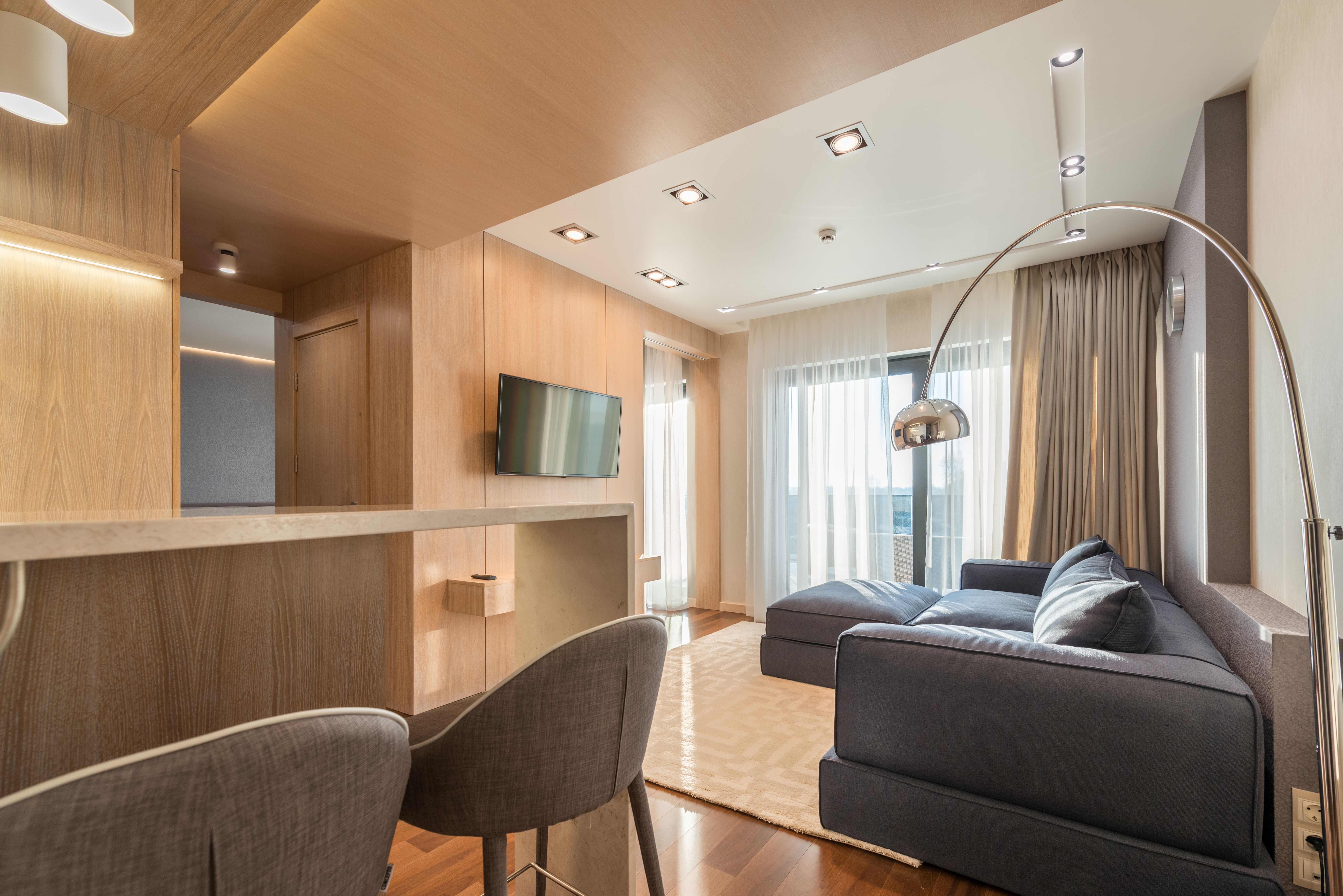 Modern Dublin Apartment Interior with TV mounted on the wall and grey sofas and chairs.